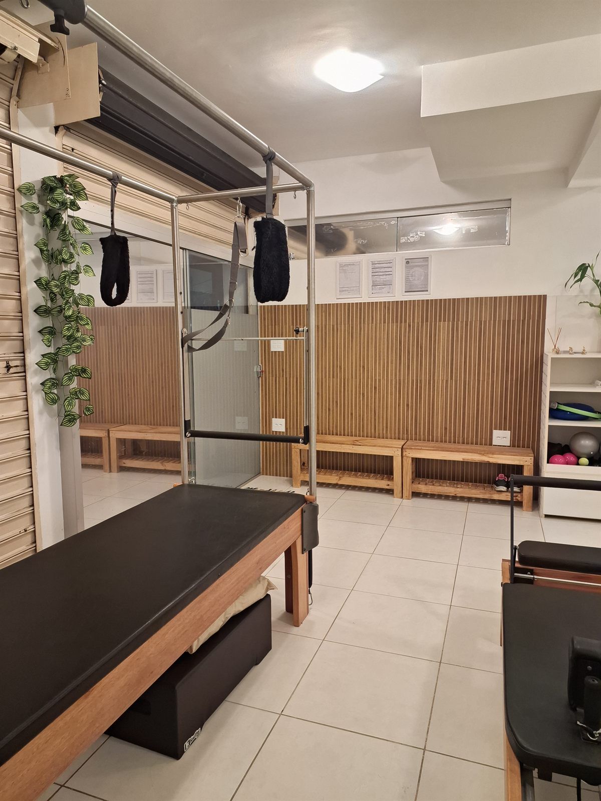 Sala ampla com Cadillac, bancos de madeira e prateleira com bolas e acessórios