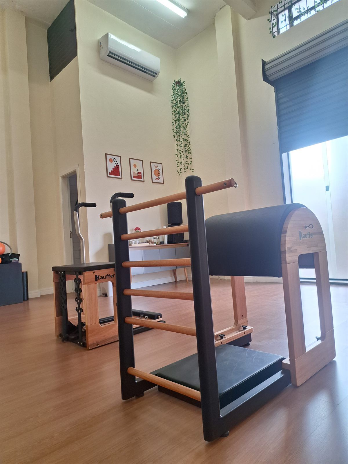 Aparelho Barrel de madeira e escada de Pilates em sala de piso de madeira